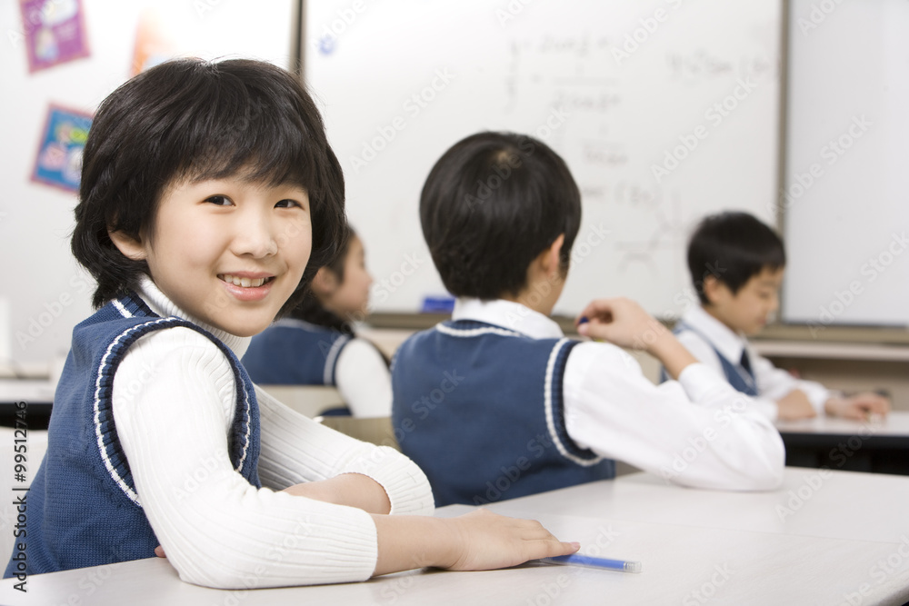 坐在教室桌子旁的年轻学生