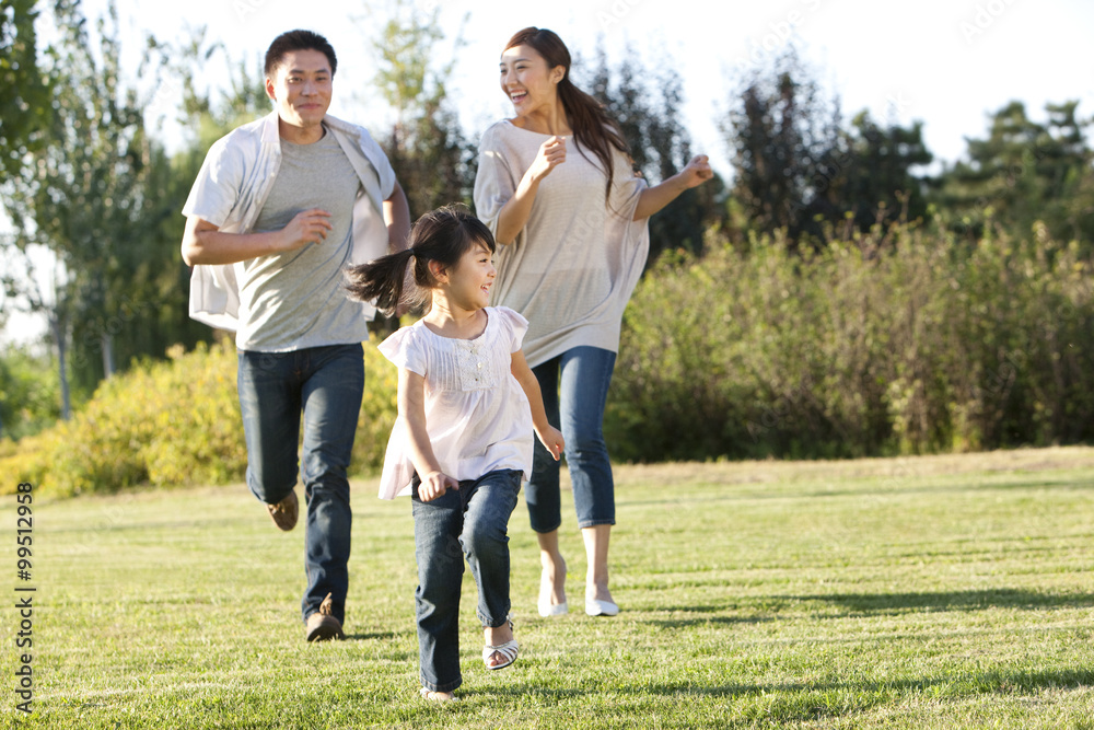 Young family running in a field