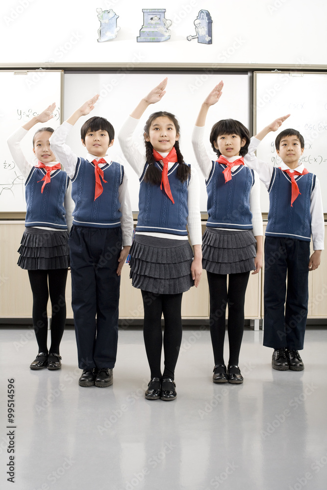 Young students saluting in a row at school