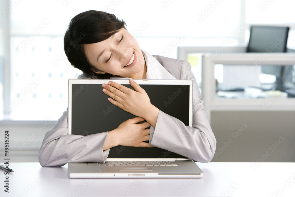 Office worker hugging her computer