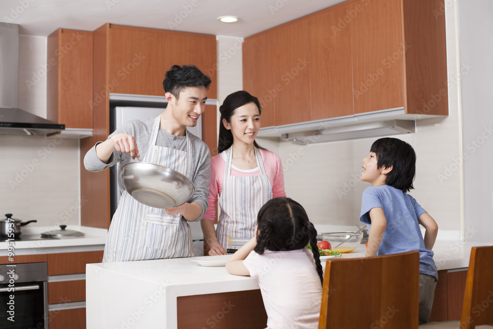 Happy young family cooking in kitchen