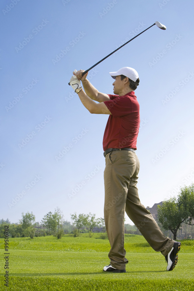 Male golfer swinging club