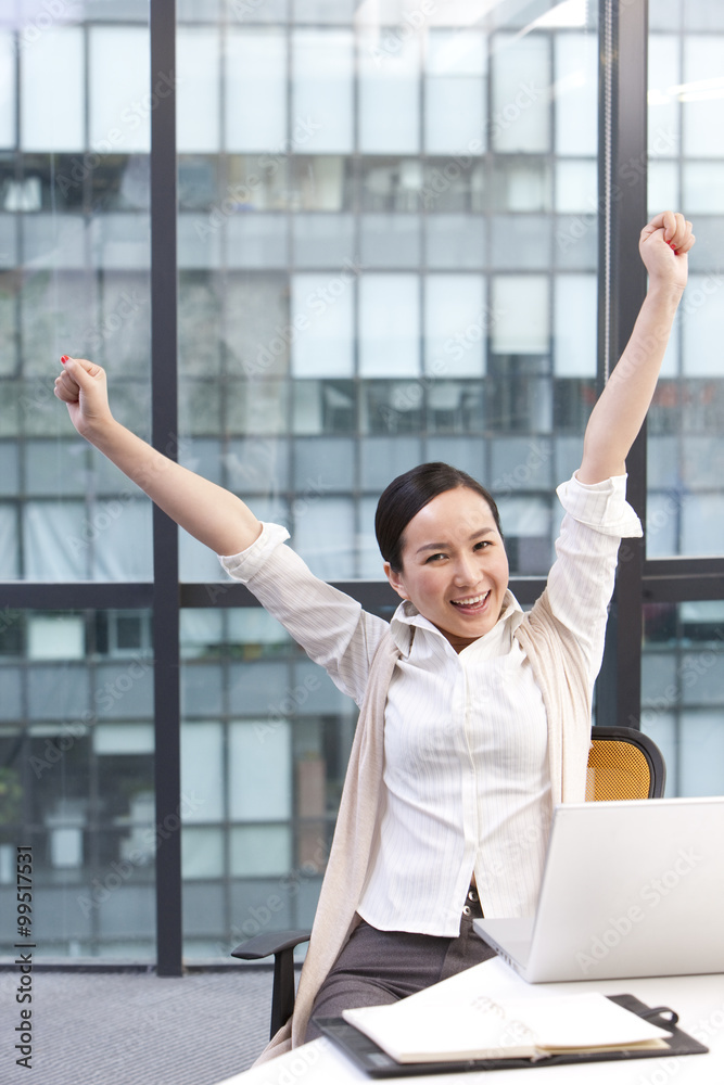 Businesswoman with arms raised in celebration