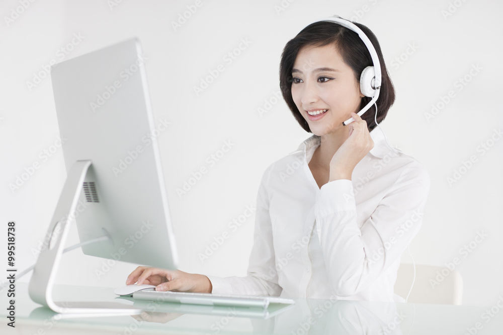 Cheerful businesswoman with headset in office