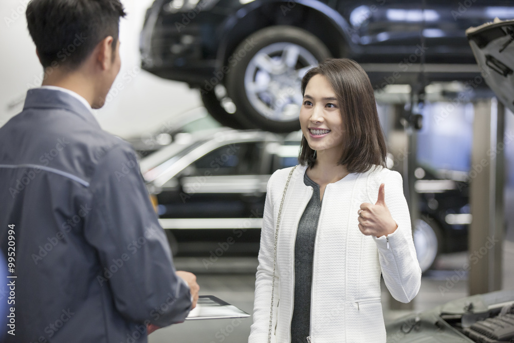 Auto mechanic talking with car owner