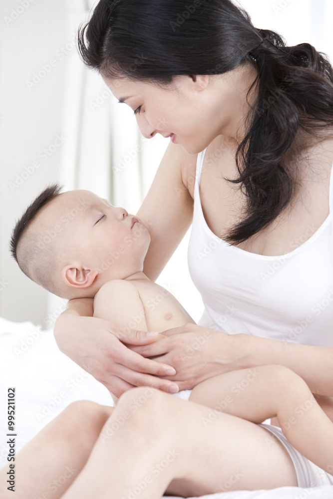 Gentle mother holding sleeping baby in arms