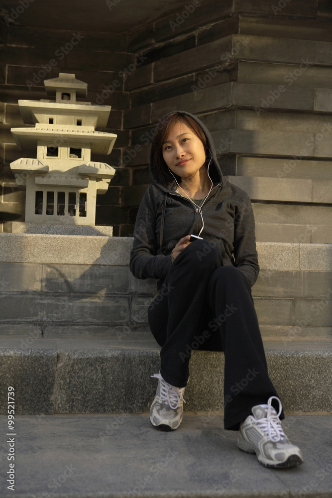 Young Woman In Sportswear Listening To Headphones