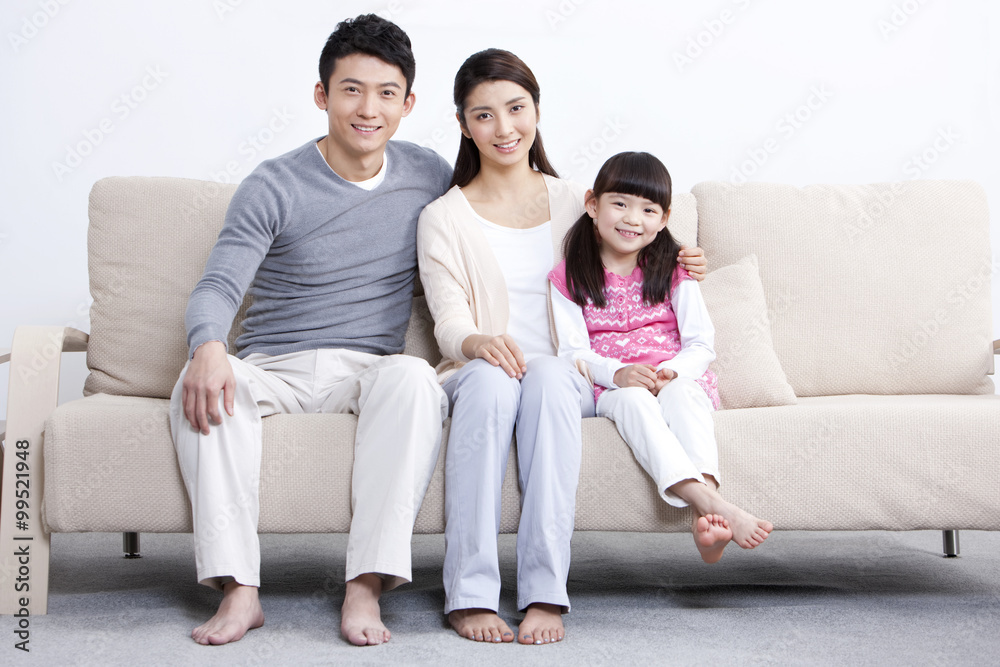 Portrait of happy young family sitting in sofa