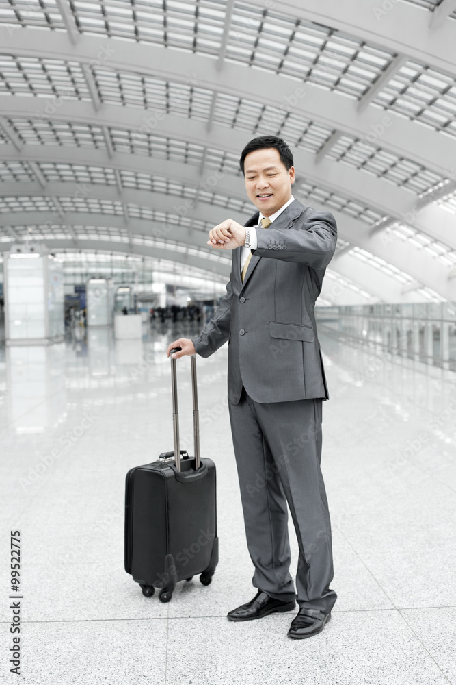 Mature businessman checking the time in airport lobby