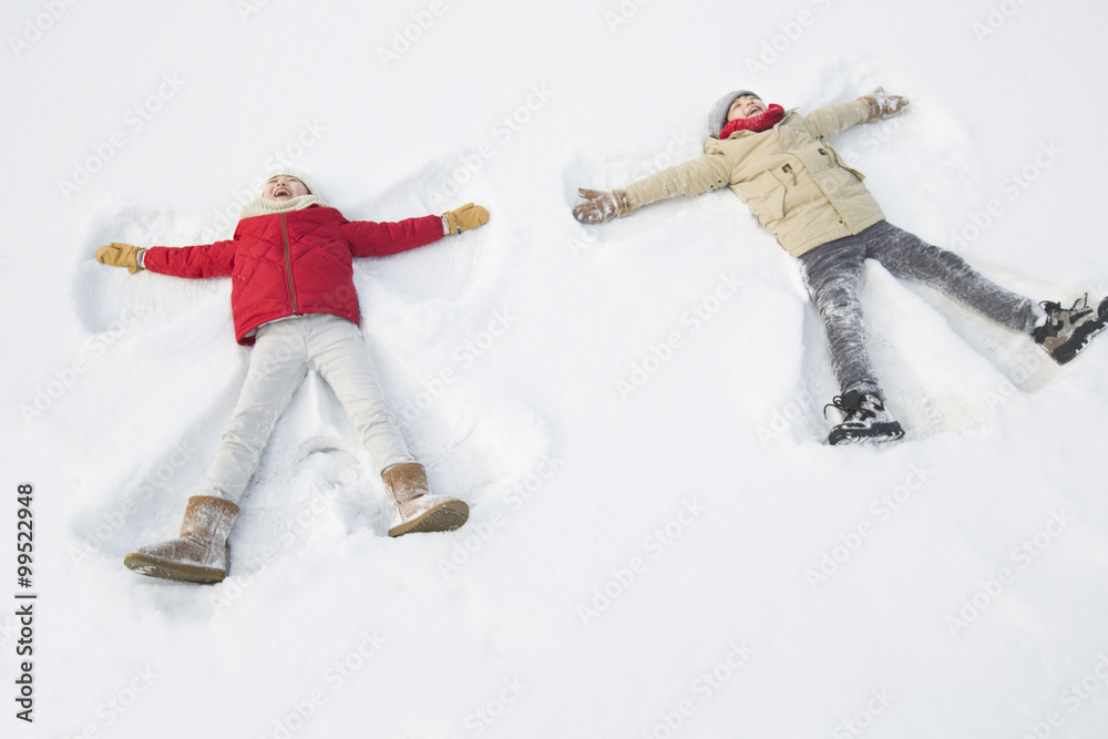 Two children making snow angels