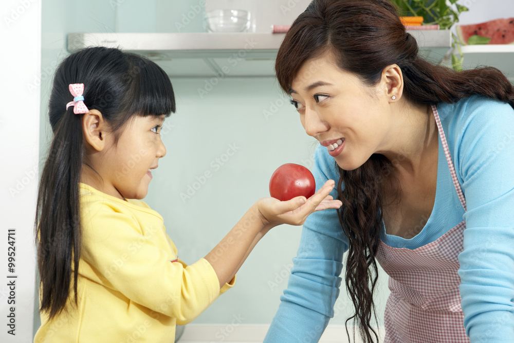 Girl Giving Mother A Tomato