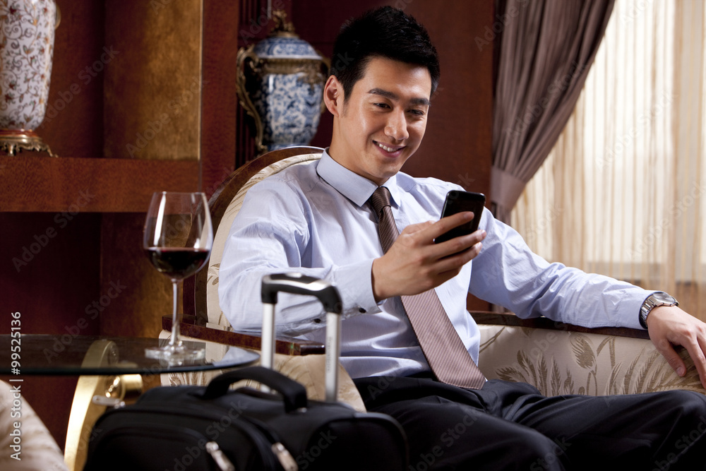 Young businessman using mobile phone in hotel