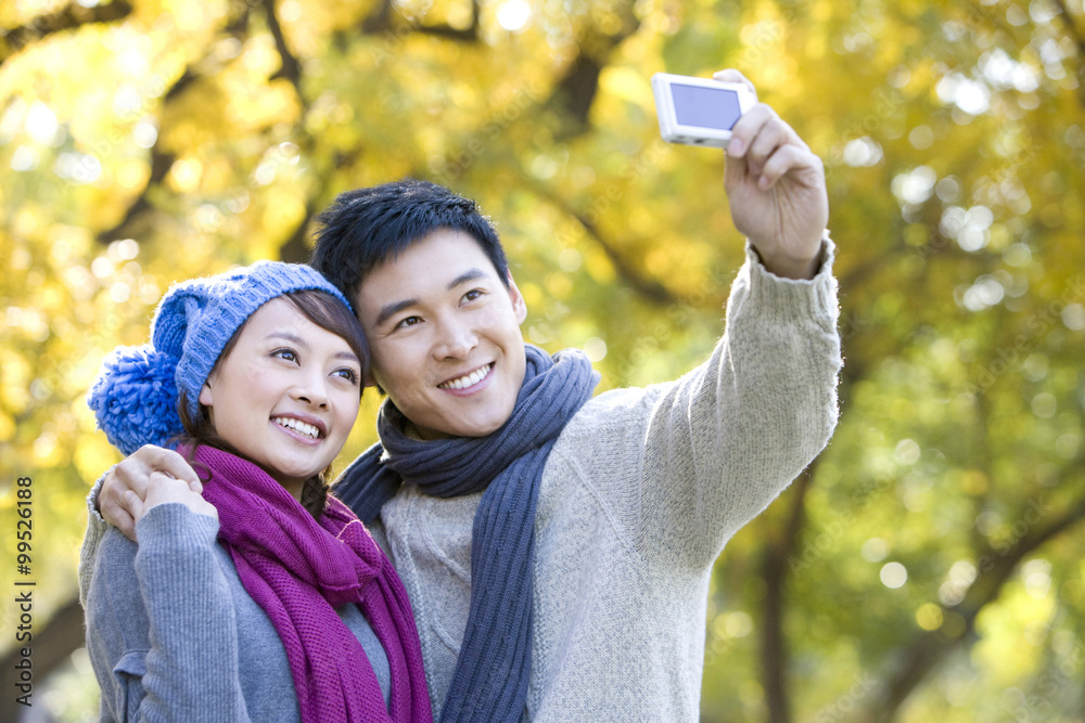 Young Couple Taking a Self Photo in a Park in Autumn