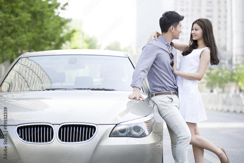 Happy young couple and car