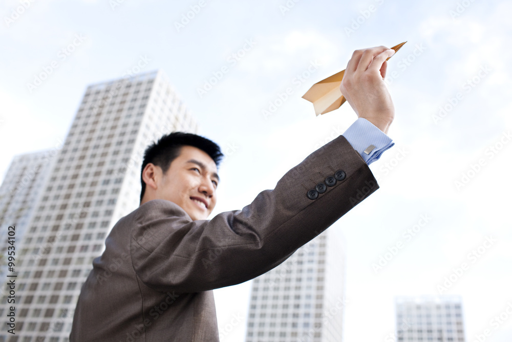 Young businessman and paper plane