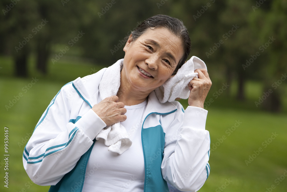 Senior Woman Wiping Her Head with a Towel after Exercising