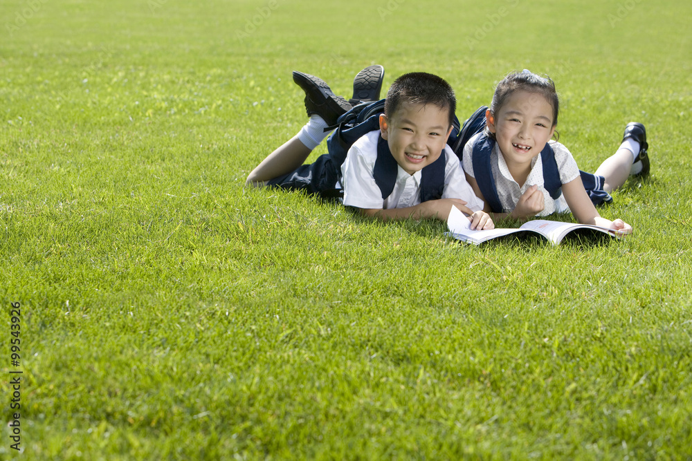 小学生在草地上读书