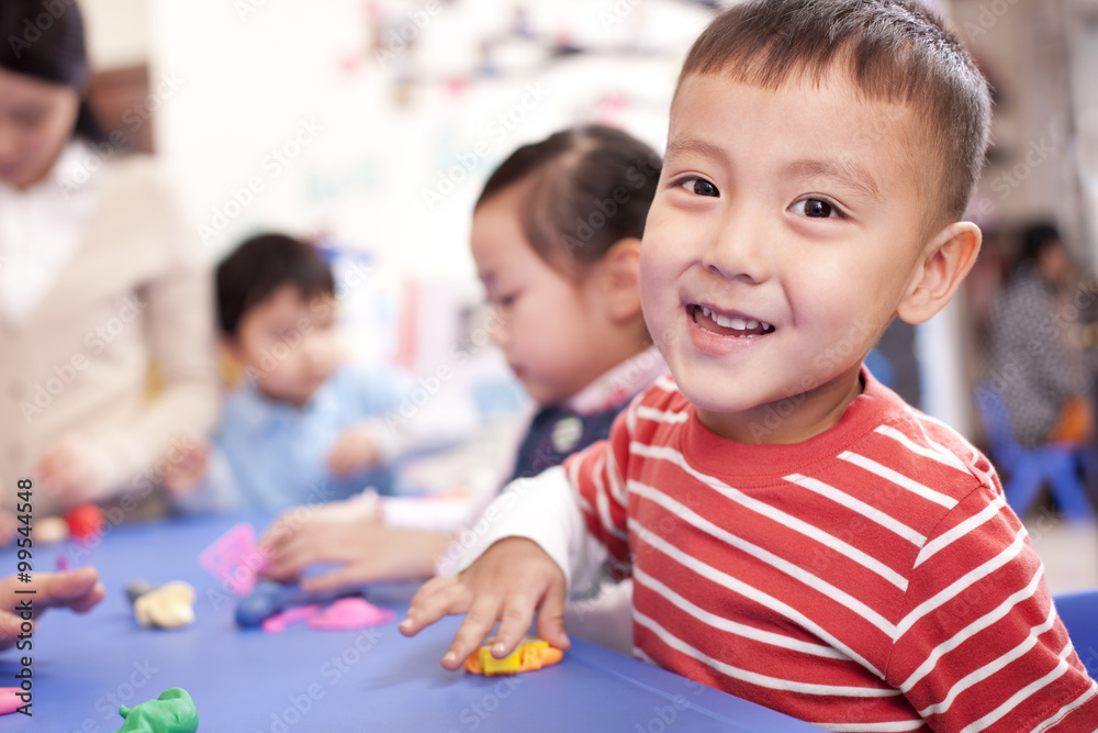 可爱的孩子在幼儿园玩橡皮泥