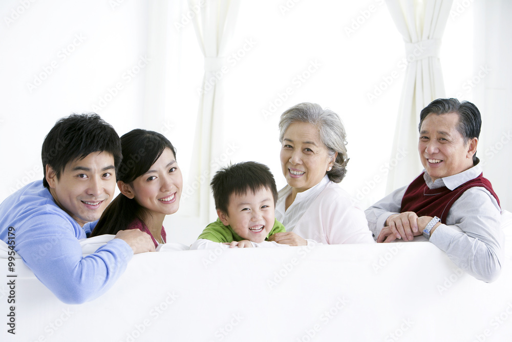 Chinese family turning around and smiling on the living room sofa