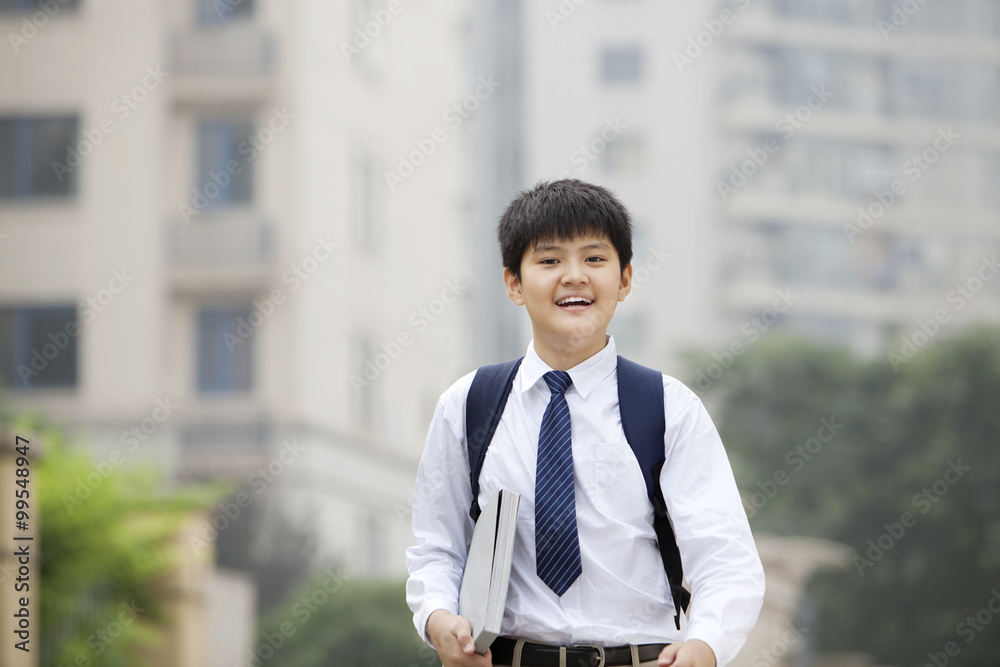 校园里穿着制服、手里拿着书的可爱男生