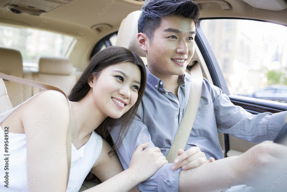 Happy young couple in a car