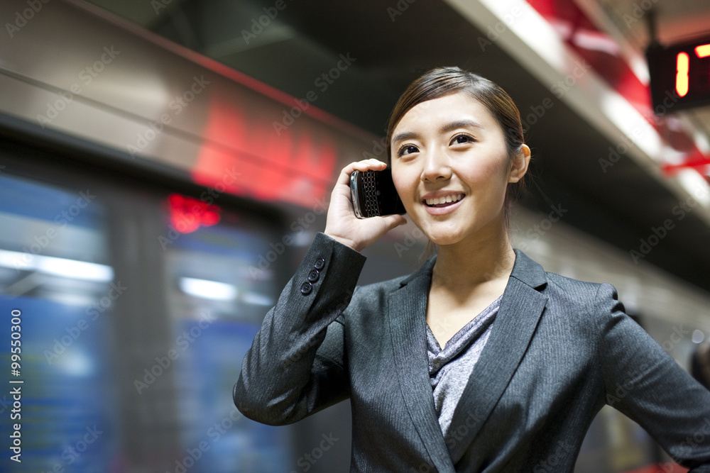 中国女商人在地铁站使用手机