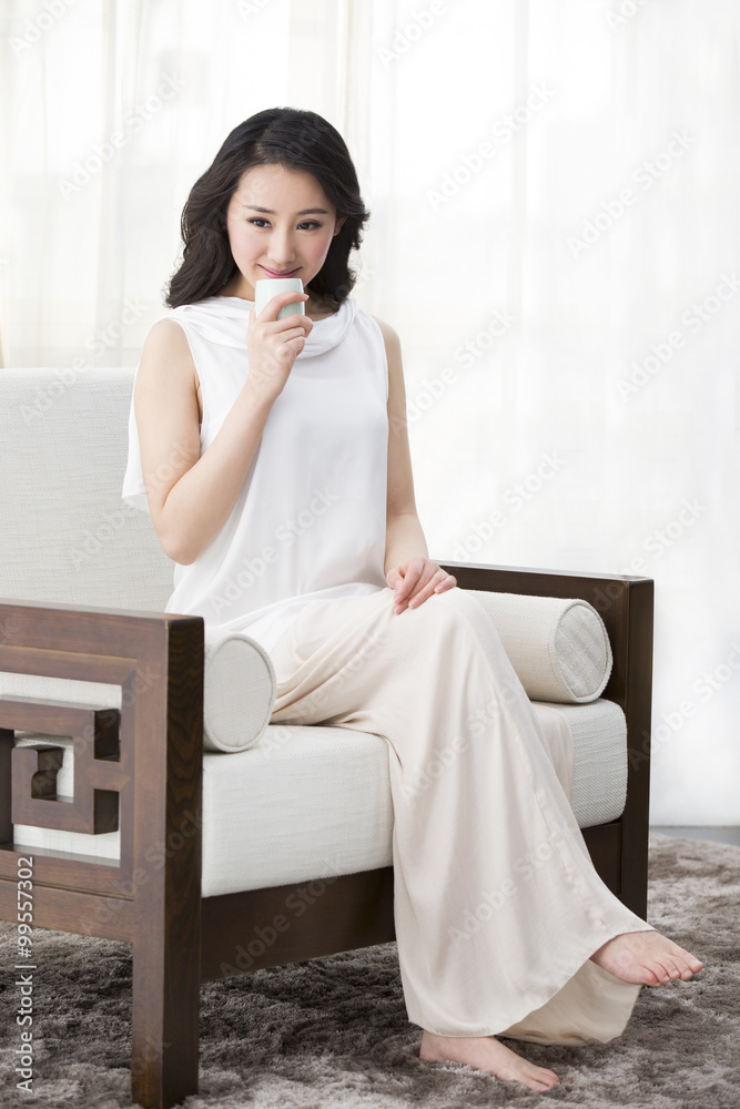 Happy young woman drinking tea