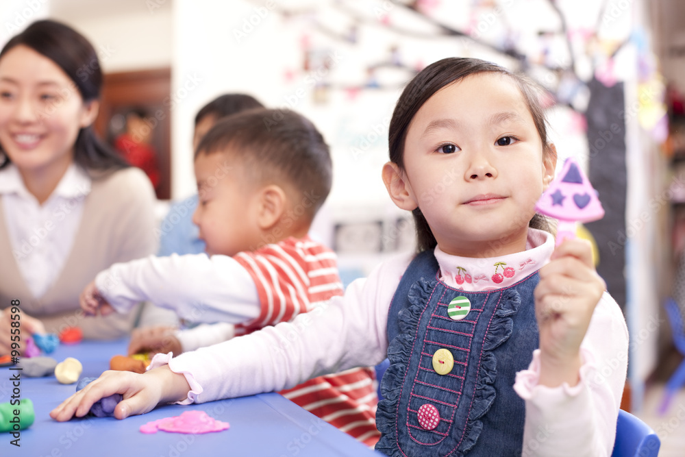 可爱的孩子在幼儿园玩橡皮泥