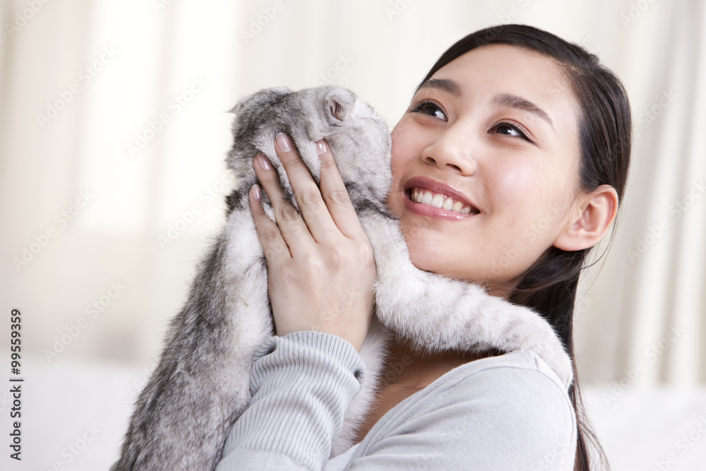 年轻女子与苏格兰折叠猫玩耍