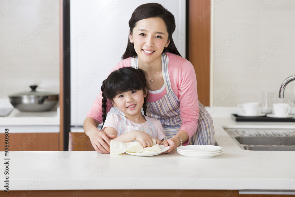 可爱的女孩给妈妈晒盘子