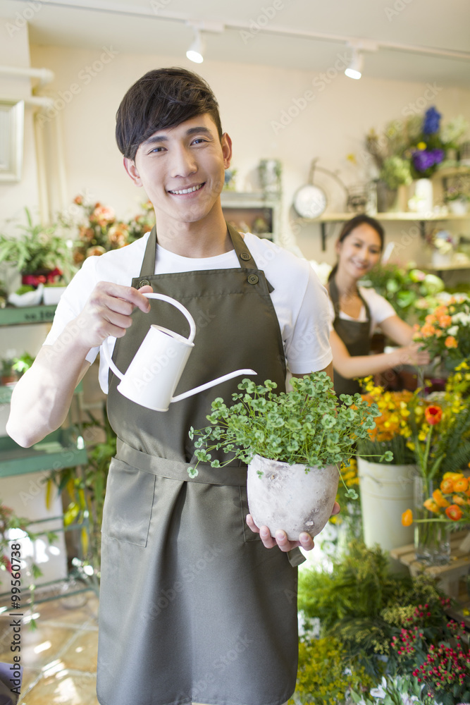 男花匠在花店给植物浇水