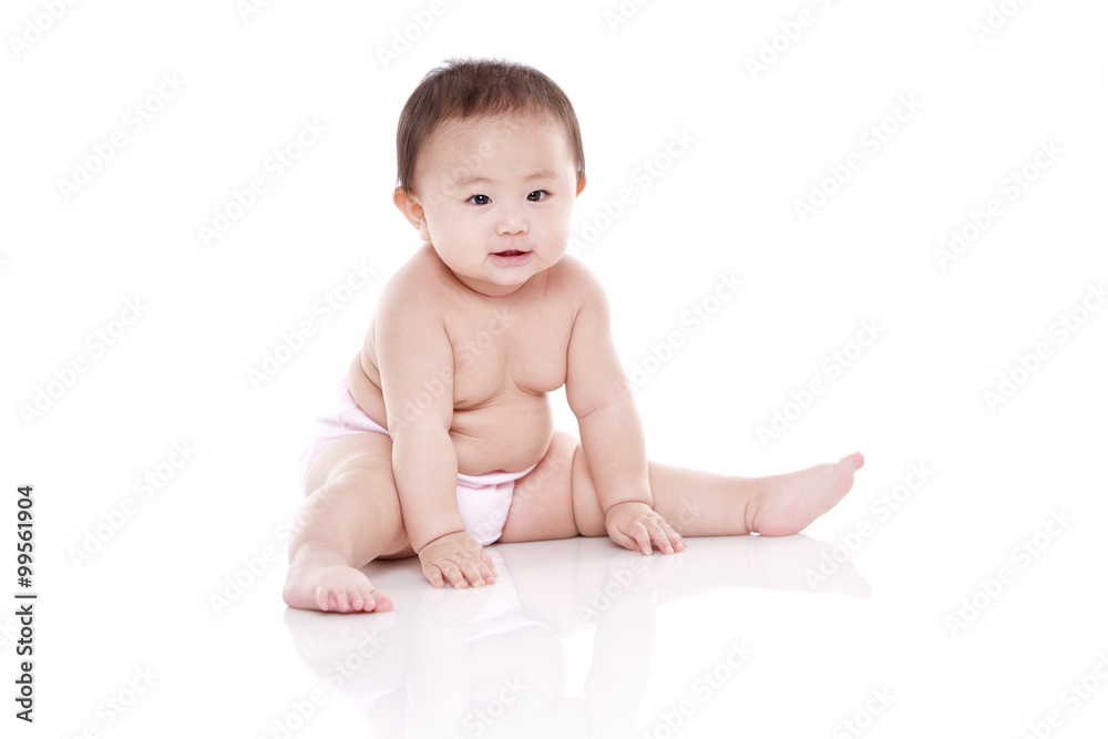 Studio shot of cute baby sitting on floor