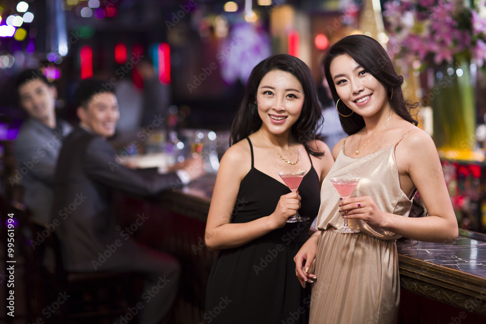 Young women drinking cocktail in bar