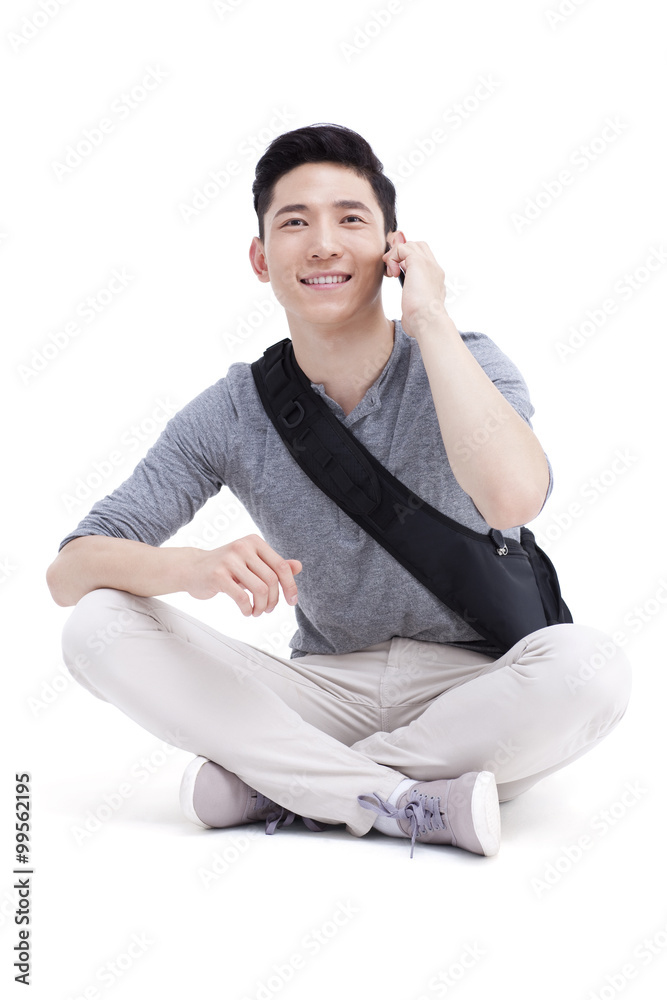 Smiling male college student talking on the phone