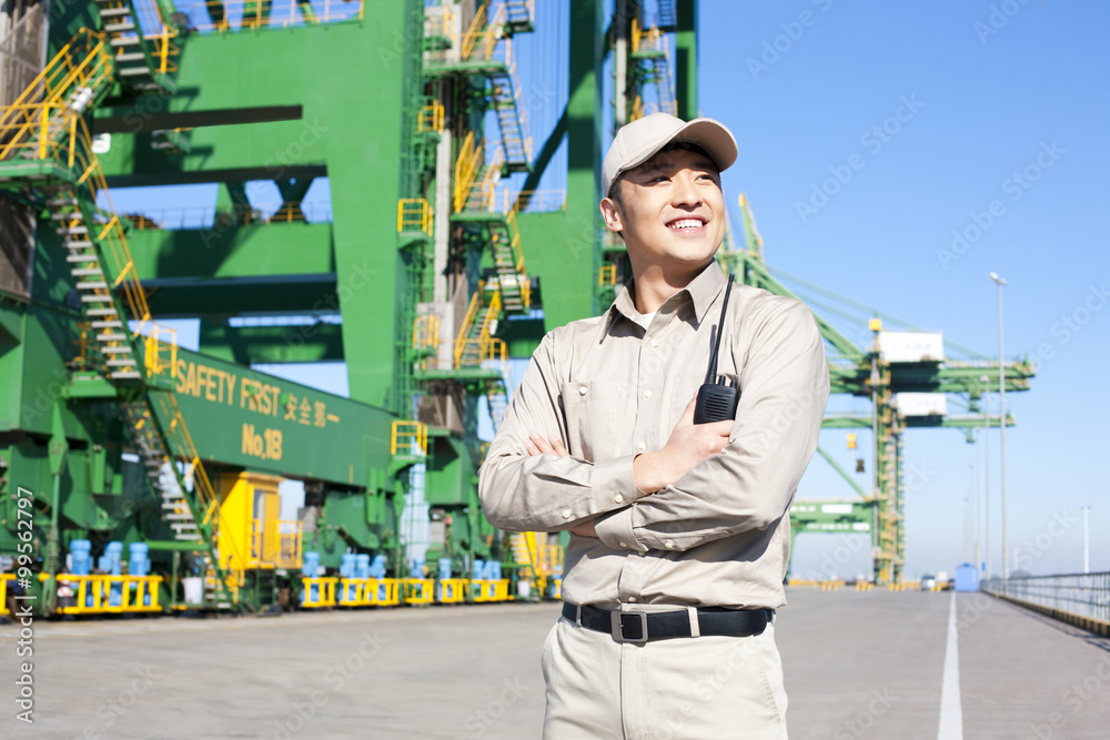 Male shipping industry worker with walkie talkie