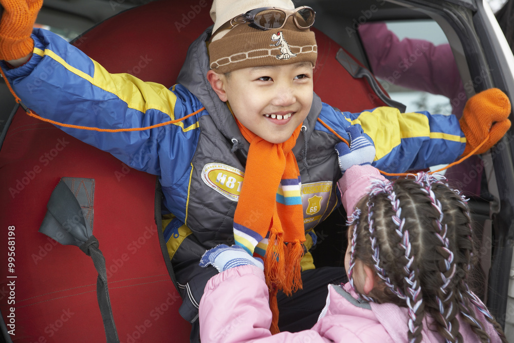 女孩把男孩从滑雪管里拉出来