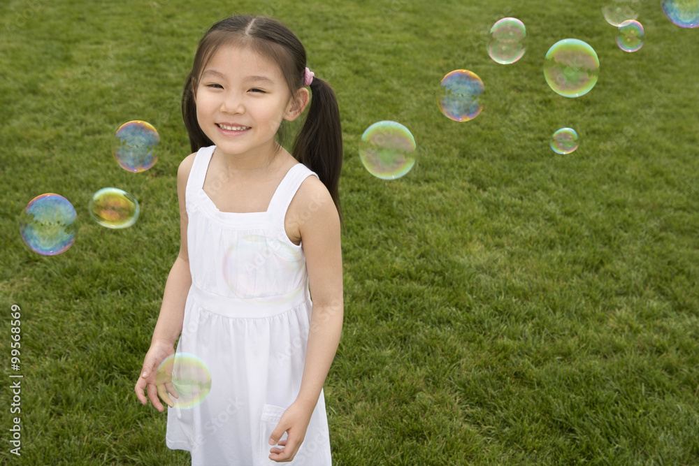 Young Girl Chasing Bubbles In Park