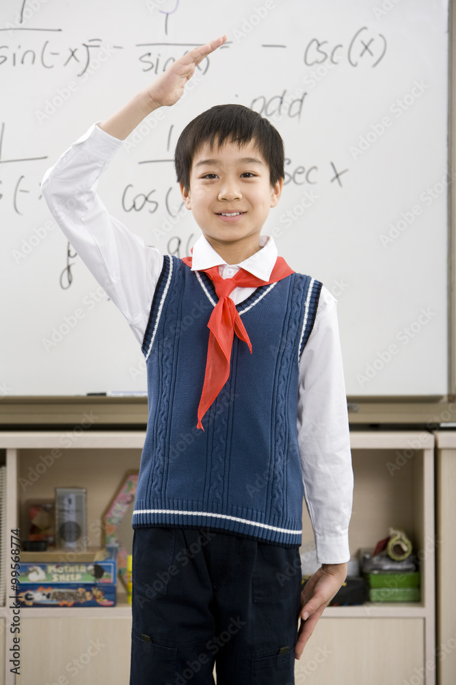 Young student saluting in front of whiteboard