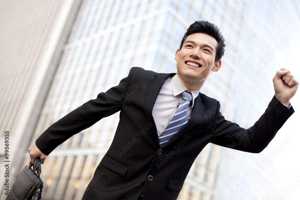 A businessman outside office buildings running