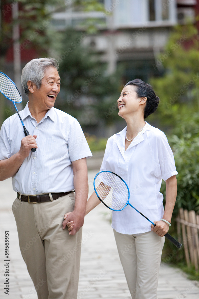 Senior couple holding badminton racket