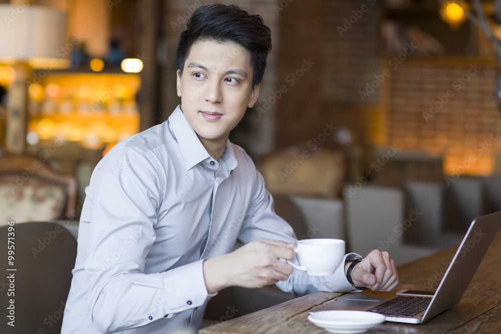 Young man using laptop in cafe