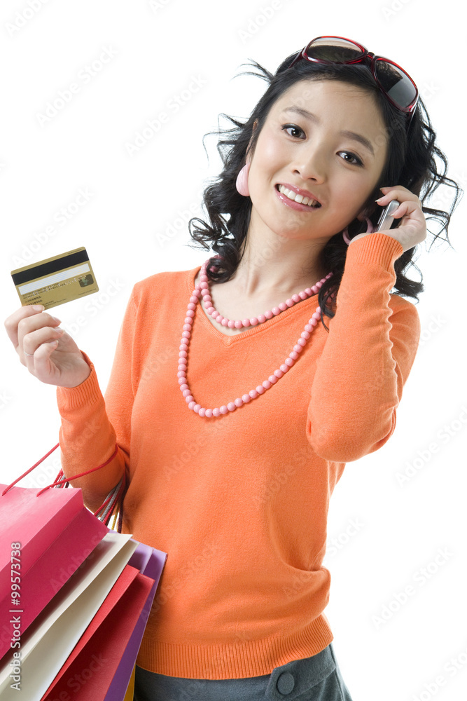 Young woman with credit card holding shopping bags