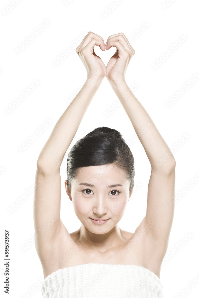 Beautiful young woman making a heart shape