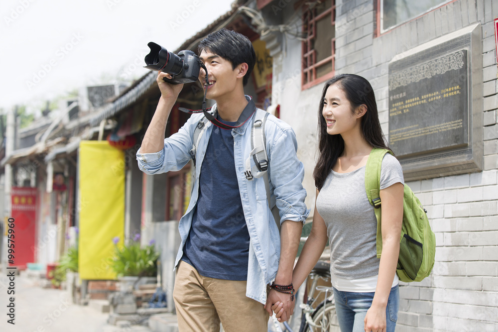 Young couple travelling in Beijing Hutong with camera