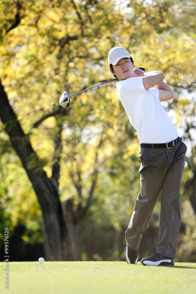 Young Man Taking a Golf Swing