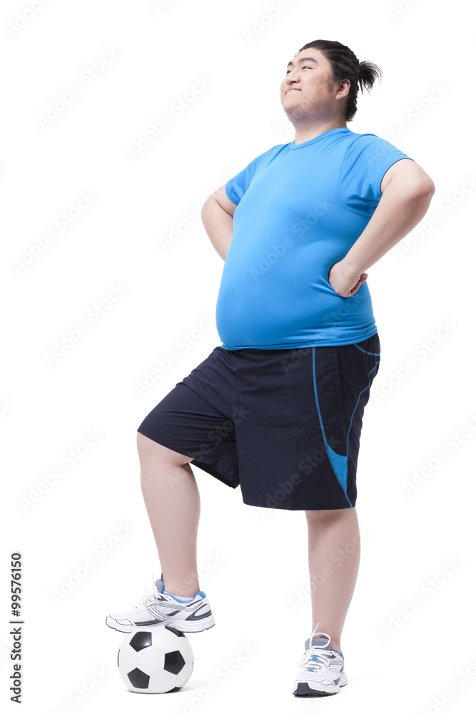 Cheerful Chubby man with foot on football