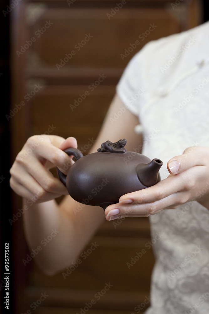 年轻女子拿着一个中国博卡罗茶壶