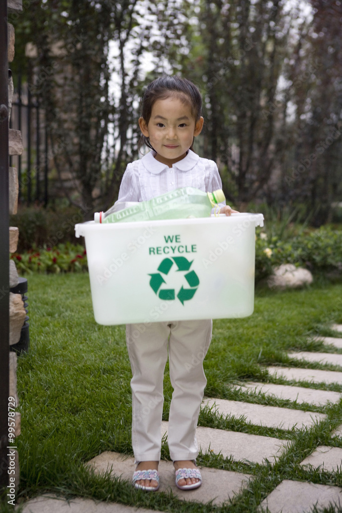 Young girl carrying recycling box