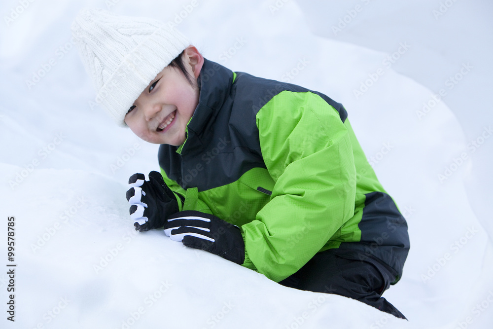 可爱的男孩在雪地里玩得开心