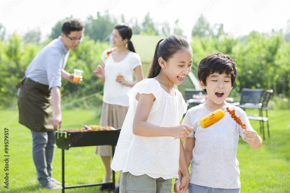 Young family barbecuing outdoors